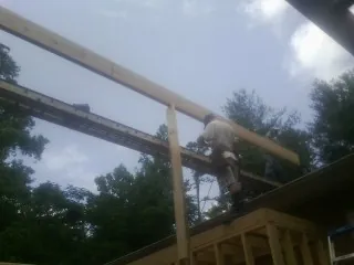 Carpenter setting a ridge beam over a new addition frame — Ice Dam Removal by Roofing Brothers in Turon