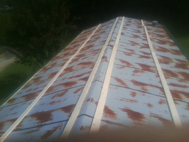 Rusted metal roof panels with new wood purlins before replacement — Storm Damage Roof Repair in Turon by Roofing Brothers